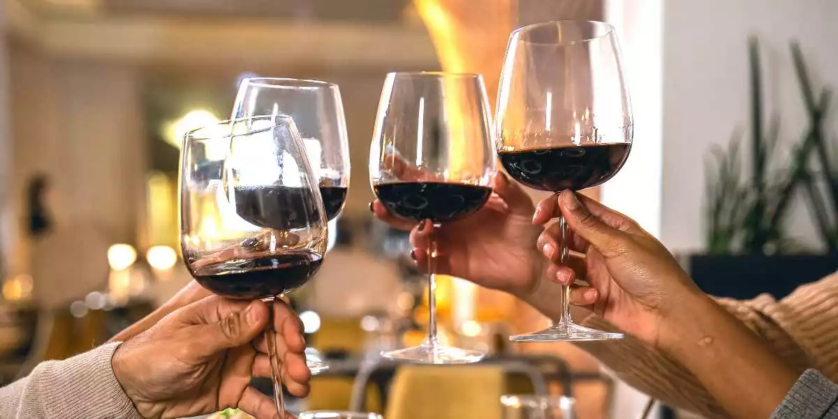 A group of people toasting wine glasses at a restaurant.