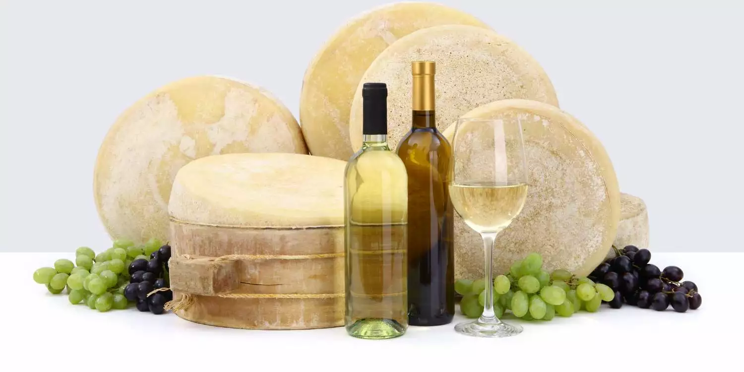 A bottle of prosecco, cheese, grapes and grapes.