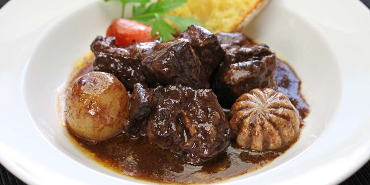 A plate of beef stew with potatoes and carrots.