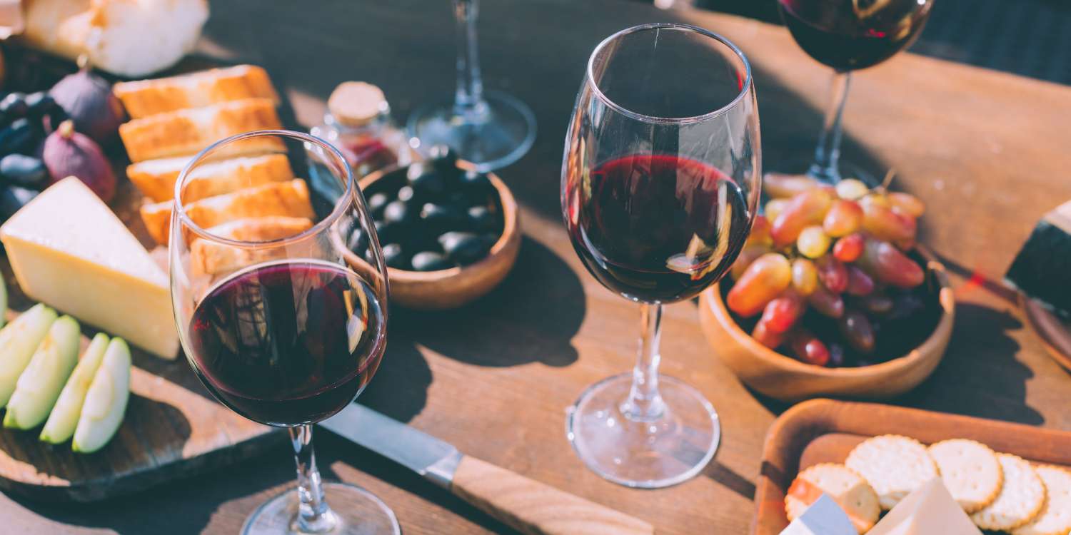 Wine, cheese and fruit on a wooden table.