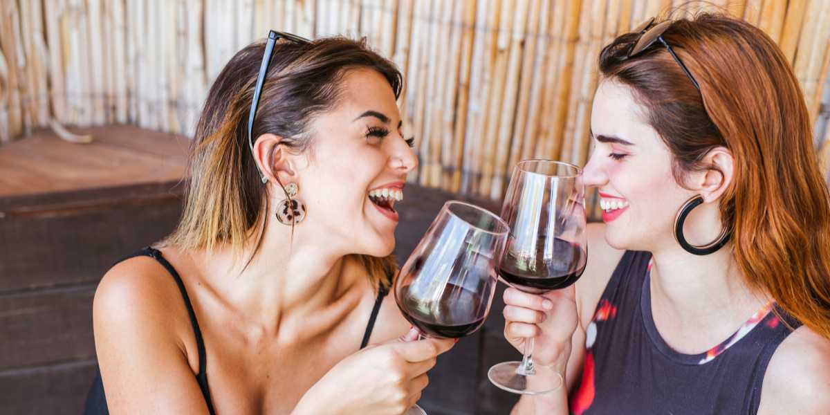 Two women are drinking red wine in a restaurant.